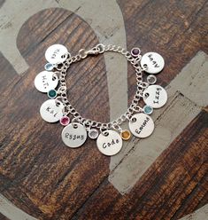 "Personalized Charm Bracelet Grandma Bracelet Grandchild Bracelet Handstamped Jewelry Mom Charm Bracelet Grandma Gift Mothers Day Gift Handstamped charm bracelet with names of loved ones. This bracelet makes a loving gift to any member of your family or friends. * 3/4\" Brushed Aluminum disc stamped with \"Names of Choice\" * Swarovski crystal birthstones of choice * Stainless Steel Chain. Samples shown are stamped in 3mm Angelina at check-out, please leave information **names **birthstone or bi Handstamped Jewelry, Grandma Bracelet, Loving Gifts, Grandma Gift, Hand Stamped Jewelry, Grandma Gifts, Stainless Steel Chain, Bracelet Making, Christmas Ideas