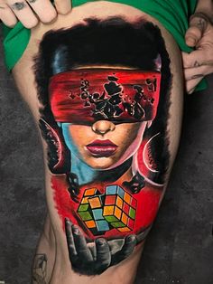 a woman with tattoos on her stomach holding a rubix cube in front of her face