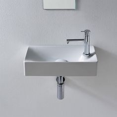 a white sink mounted to the side of a wall