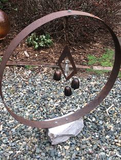 a metal sculpture sitting on top of a pile of rocks