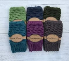 four knitted fingerless mittens are lined up on a white wood background with the words, wine women written in brown lettering