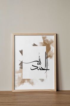 an arabic calligraphy is displayed in a wooden frame on a shelf next to a wall