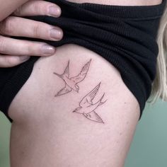 a woman's thigh with two birds tattoo on her left side ribcage