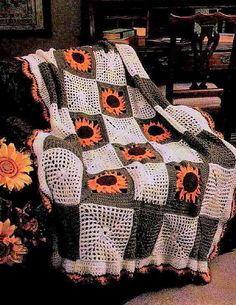 a crocheted blanket with sunflowers on it in front of a chair