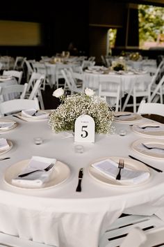 the table is set with white linens and silverware