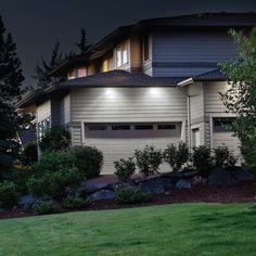 a house that is lit up at night with the lights on in front of it