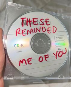 there is a cd with writing on it and someone holding the disc in their hand