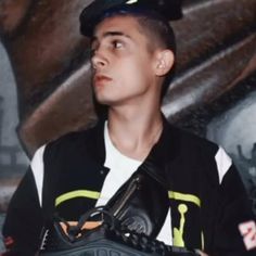 a young man wearing a catchers mitt in front of a wall