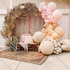 a bunch of balloons that are in front of a house with a wreath on the ground