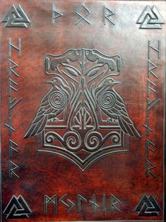 a leather book with an eagle on the front and two different symbols in the middle