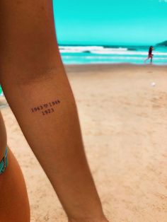 a woman's arm with the words mellow lane written on it and a beach in the background