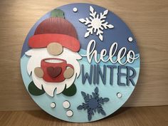 a wooden sign that says hello winter with a santa clause holding a cup of coffee