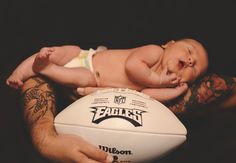 a baby laying on top of a white football