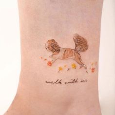 a small dog tattoo on the ankle that reads walk with me and is running through flowers