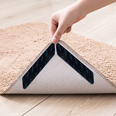 a person is touching the bottom of a rug with their thumb on it's tip