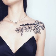 a woman wearing a black dress with flowers on her chest