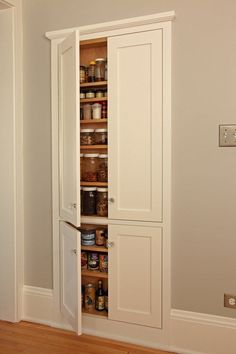 an open pantry cabinet in the corner of a room