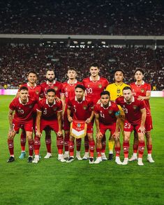 a group of men standing on top of a soccer field