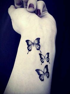 a woman's arm with three butterflies on it and one is black in color