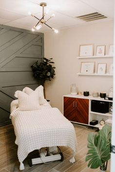 a white bed sitting next to a green plant on top of a hard wood floor