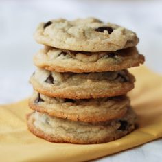 a stack of chocolate chip cookies sitting on top of a yellow napkin