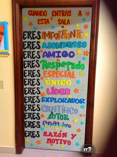 a bulletin board with spanish words on it in a hallway next to a door that says,