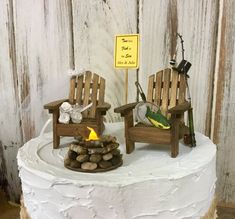 two wooden chairs sitting on top of a white cake covered in frosting and rocks