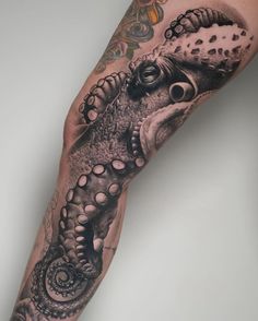 an arm with tattoos on it that has a large alligator in the middle of it