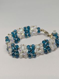 a blue and white beaded bracelet with crystal beads on a white tablecloth background