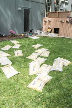 many bags are laid out on the grass in front of a house with a doghouse