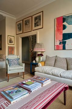 a living room filled with furniture and pictures on the wall above it's coffee table