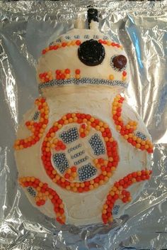 a star wars cake is decorated with orange and blue candies in the shape of a bbg