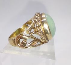 A large vintage 9ct gold cabochon green jade ring with pierced floral shoulders.  Perfect condition Fully hallmarked for 9ct gold UK size N, US size 6 1/2 The front of the ring measures 1.5cm at the widest point and sits at 1cm off the finger Antique Gold Emerald Cabochon Ring, Vintage Gold Emerald Cabochon Ring, Antique Yellow Gold Cabochon Emerald Ring, Antique Yellow Gold Emerald Cabochon Ring, Vintage Jade Cabochon Ring, Vintage Jade Rings For Formal Occasions, Antique Emerald Ring In Gold With Oval Cabochon, Antique Gold Emerald Ring With Oval Cabochon, Vintage Green Oval Filigree Ring