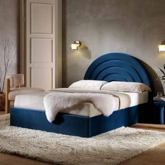 a bed with blue headboard and foot board on top of carpeted flooring