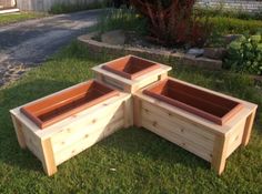 three wooden planters sitting in the grass