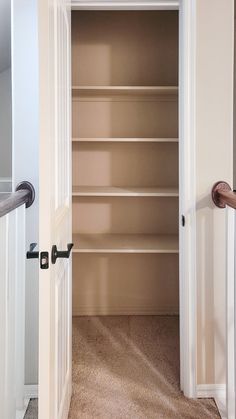 an open door leading to a walk in closet with shelves on both sides and doors closed