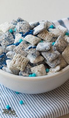 a bowl filled with blue and white dog treats on top of a striped table cloth