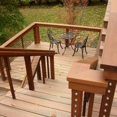 a wooden deck with chairs and table on it