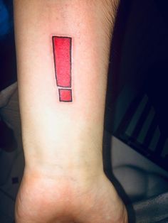 a person's wrist with a red object on it