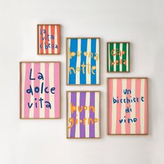 four framed art pieces on the wall with words written in different colors and sizes, including stripes