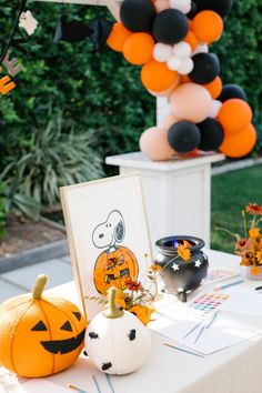 a table topped with pumpkins and balloons