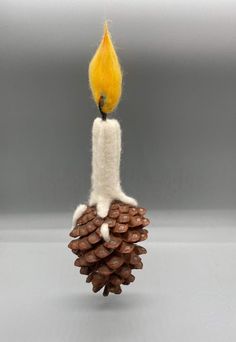 a pine cone with a lit candle on it