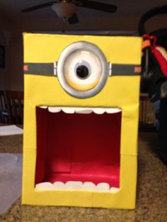 a yellow cardboard box with an eye and mouth