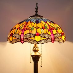 a lamp that is sitting on top of a table next to a light fixture with a dragonfly design on it