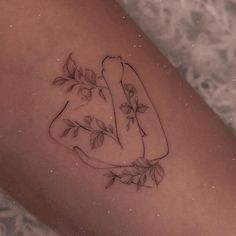 a woman's leg with a tattoo on it that has leaves and a hot dog in the shape of a heart