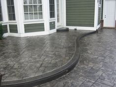 an outdoor patio with steps leading up to the front door and two windows on each side