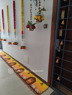 an entrance way decorated with colorful garlands and hanging pots filled with flowers on the wall