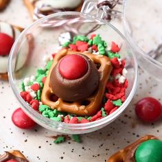 some christmas treats are in small glass bowls on a table with candy and candies