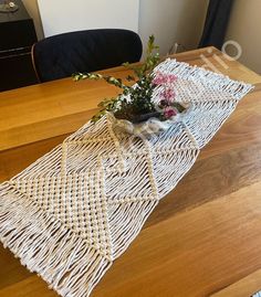 a table with some flowers on top of it and a chair in the back ground