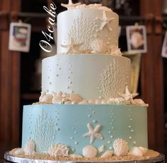 a three tiered cake with starfish and shells on it